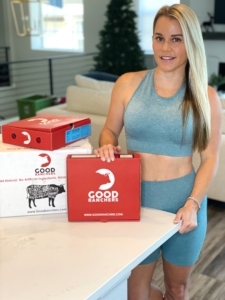 blonde standing with red shipping boxes