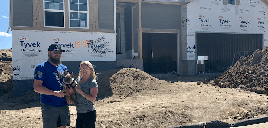 Couple standing in front of new home construction in Denver