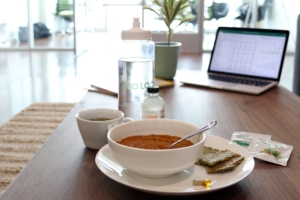 soup on kitchen table with crackers and computer screen