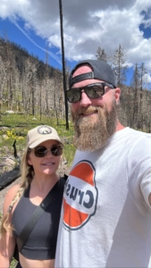 woman and man taking a selfie on hiking trail in mountains