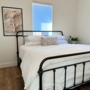 black iron bed with white pottery barn bedding in a bedroom
