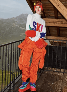 Woman wearing Ski sweater and orange pants with an orange jacket tied around her waist