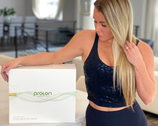 blonde woman standing next to Prolon 5-day Diet box